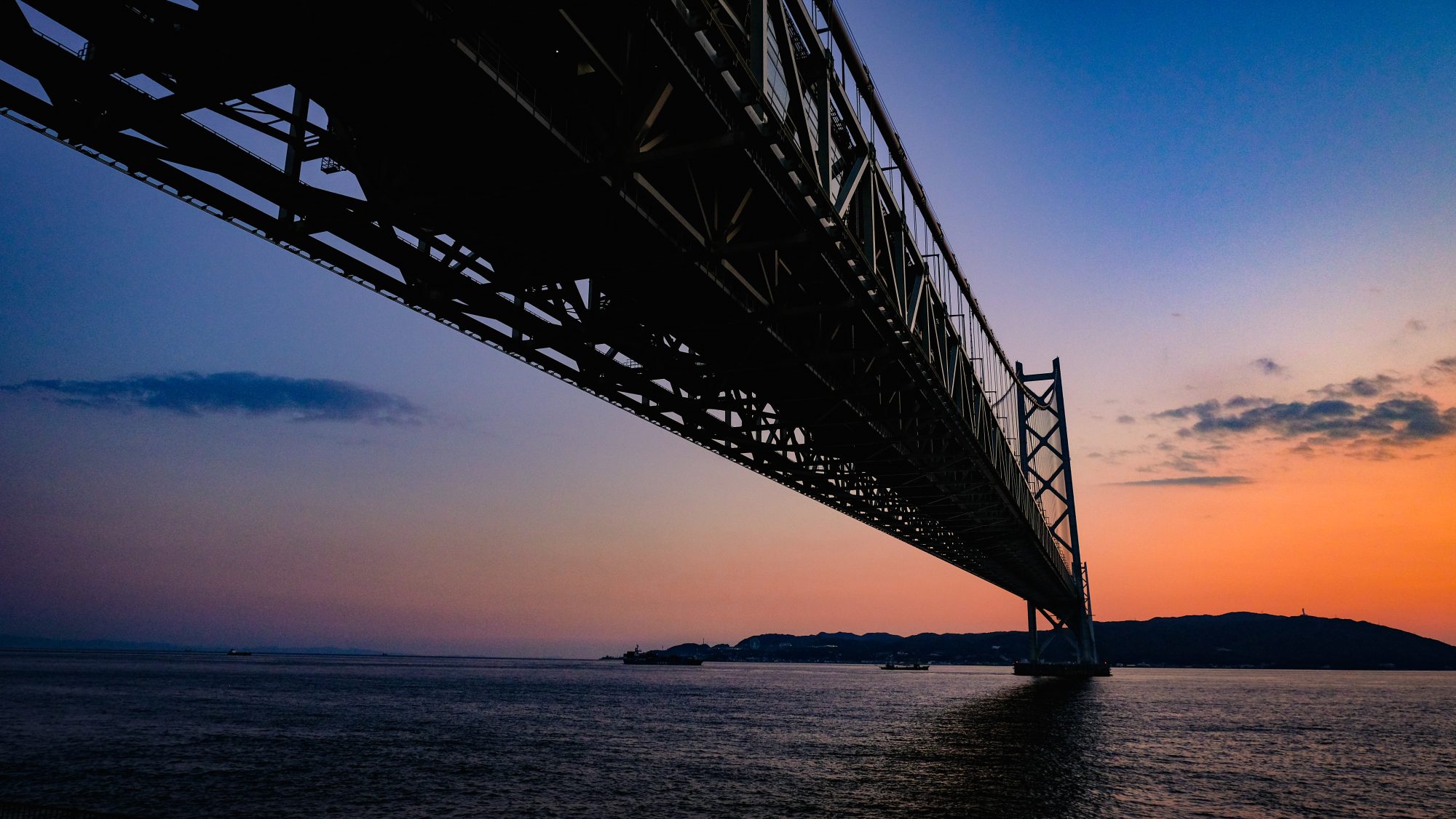 A large bridge and blue/orange sky